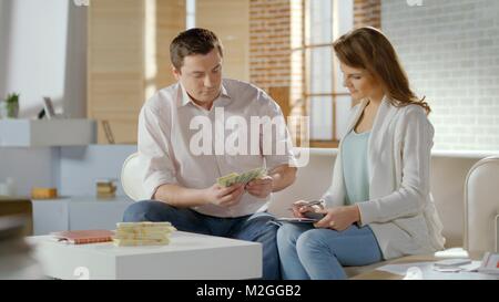 Il successo della coppia di coniugi Conteggio contanti presso la casa famiglia di fondi di bilancio, risparmi HD Foto Stock