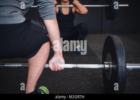 Sollevamento pesi, powerlifting, crossfit l uomo e la donna che lavora fuori in palestra. Foto Stock