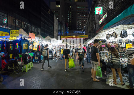 La gente che camminava nelle luci di un mercato di notte a Bangkok, in Thailandia Foto Stock