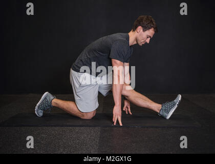 Uomo caucasico nella sua 30s di stretching e di stendere i muscoli dopo allenamento. Foto Stock