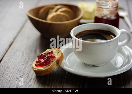 La prima colazione con caffè, pane burro e marmellata. Close up Foto Stock