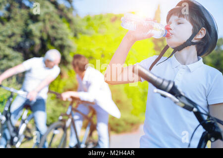 Ragazzo sportivo acqua potabile dopo la bicicletta equitazione Foto Stock