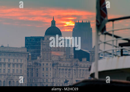 Il Liverpool Cattedrale Anglicana di distanza con un inizio di mattina orange il sorgere del sole sopra il Liverpool waterfront. Foto Stock