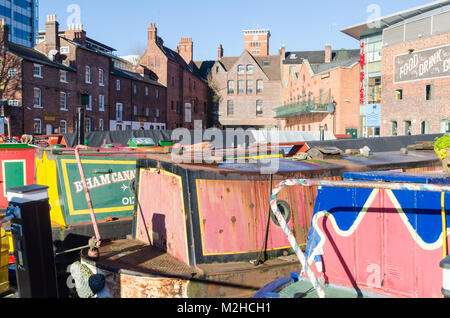 Narrowboats colorate ormeggiate nei Gas Street Basin nel cuore della rete dei canali di Birmingham, UK su una soleggiata giornata invernale e Foto Stock