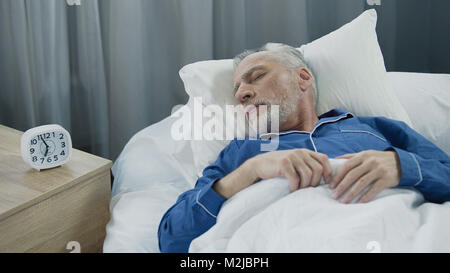 Senior uomo dorme nel letto la mattina, un sano riposo durante il tempo di ripristino, stock footage Foto Stock