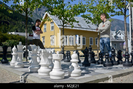 Due amici a giocare a scacchi su una scacchiera gigante, Odda, Norvegia Foto Stock