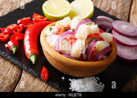 Snack ceviche di pesce bianco con cipolla e pepe vicino fino in una ciotola sul tavolo orizzontale. Foto Stock