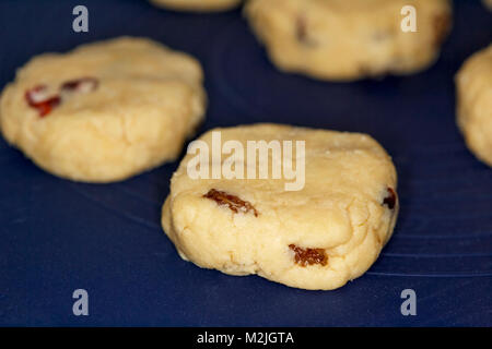 Fatto in casa focaccine di frutta nota come torte di roccia su un silicone Tappeto di cottura pronta per andare in forno Foto Stock