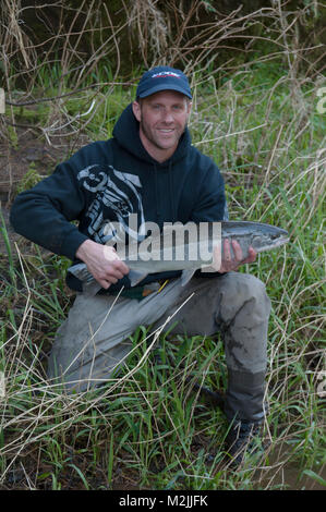 Trota Steelhead pescatori con un incubatoio allevati Siletz river steelhead catturati su un galleggiante guidato viaggio. Il modello release, solo uso editoriale. Foto Stock