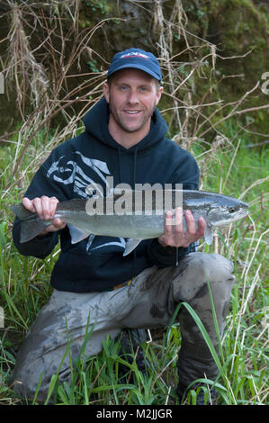 Trota Steelhead pescatori con un incubatoio allevati Siletz river steelhead catturati su un galleggiante guidato viaggio. Il modello release, solo uso editoriale. Foto Stock