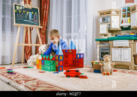 Un ragazzo sta giocando da un costruttore magnetico nella stanza dei bambini. Giocattoli intellettuale Foto Stock