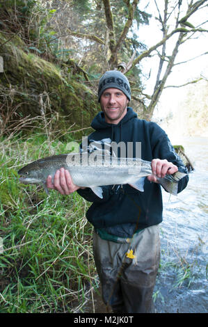 Trota Steelhead pescatori con un incubatoio allevati Siletz river steelhead catturati su un galleggiante guidato viaggio. Il modello release, solo uso editoriale. Foto Stock