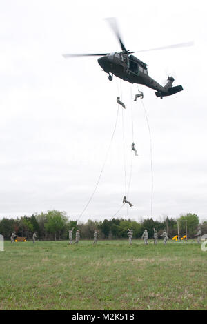 Soldati e Airment rappel da un UH-60 Black Hawk elicottero durante un assalto dell'aria di corso presso il Camp Gruber, Okla., ospitato dall'Oklahoma Guardia Nazionale. Durante il corso il servicemembers imparare il modo corretto di rig e controllare le attrezzature necessarie per essere caricato di imbracatura dal di sotto da un elicottero e in modo sicuro il rappel da un elicottero da fino a 100 piedi sopra il terreno. Air Assault Rappel giorno 31 da Oklahoma Guardia Nazionale Foto Stock