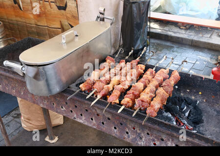 Un girarrosto con carboni per la cottura di carne in salamoia su spiedini. Outdor street food concept foto Foto Stock