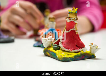 Plastilina colorata persone: un letto queen-come figurine con un rosso abiti lunghi Foto Stock