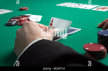 Tavolo del poker durante una partita. Quattro schede di aces tenendo in mano. Chip e carte sul tavolo. Foto Stock