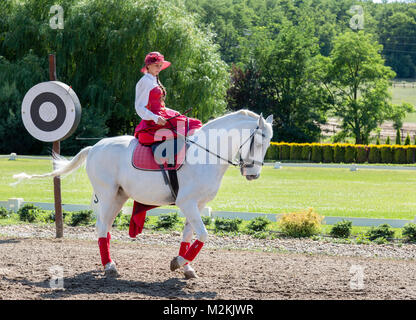 Signora giovane in equestre tradizionale abito ungherese, in mostra a cavallo. Foto Stock