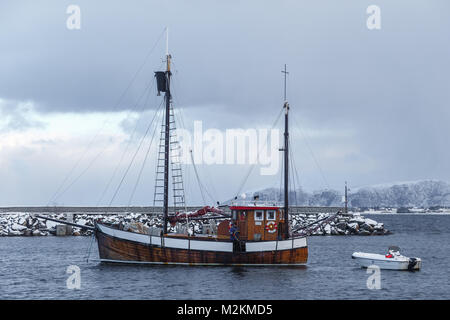 ALNES, NORVEGIA- Gennaio 06, 2018: i pescatori la pulizia del tagliente dopo la metà del pesce. Marina in Alnes a Godoya isola vicino a Alesund. Paesaggio invernale. N Foto Stock