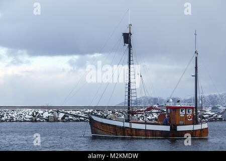 ALNES, NORVEGIA- Gennaio 06, 2018: i pescatori la pulizia del tagliente dopo la metà del pesce. Marina in Alnes a Godoya isola vicino a Alesund. Paesaggio invernale. N Foto Stock