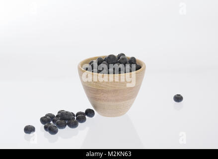 Vaccinium corymbosum. I mirtilli in un vaso di legno. Foto Stock