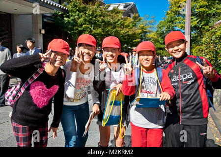 KYOTO, Giappone-ott 24,2014: scuola giapponese bambini con cappucci rossi ridere in strada il Ott 24, 2014, Kyoto, Giappone. Foto Stock