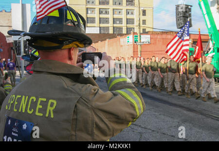 Un vigile del fuoco di Vigili del Fuoco di New York si affaccia su come Marines dal 1° Marine Corps District, piombo da Col. J. J. aneto, il 1MCD comandante, marzo prima dell' inizio del tunnel per le torri run, Sett. 29. Tunnel di torri, a 5 chilometro di eseguire, si tiene ogni anno in onore del pompiere Stephen Siller. Siller, che correva per la World Trade Center attraverso il Tunnel della batteria con tutta la sua marcia su durante gli attacchi su 9/11, in definitiva ha perso la vita durante il suo tentativo di salvare gli altri. (U.S. Marine Corps photo by Capt. Timothy irlandesi). 130929-M-JJ315-004 da NYCMarines Foto Stock