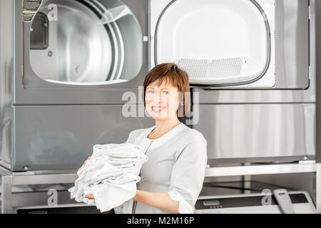Senior washwoman nel servizio lavanderia Foto Stock