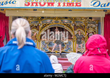 Guarda gli astanti giovani ballerine in abbigliamento militare preforma sulla fiera organo, Masham, North Yorkshire, Regno Unito Foto Stock