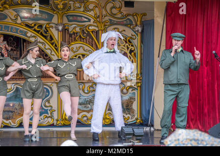 Danzatrici in costume militare bracci di collegamento con connettore maschio di tipo ballerina in costume di pecora per fare il cancan mentre un uomo che canta, Masham, North Yorkshire, Regno Unito Foto Stock