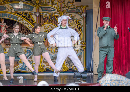 Danzatrici in costume militare bracci di collegamento con connettore maschio di tipo ballerina in costume di pecora per fare il cancan mentre un uomo che canta, Masham, North Yorkshire, Regno Unito Foto Stock