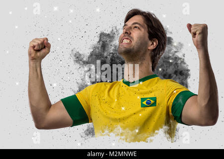 Calcio brasiliano giocatore uscente da un soffio di fumo. celebrando. Foto Stock