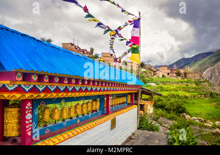 Esplorazione locale mostra ruote della preghiera e la preghiera flag in un piccolo villaggio chiamato Manang, catturati durante il circuito di Annapurna trek nella stagione dei monsoni Foto Stock