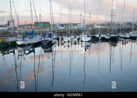 Barche e yacht ormeggiati a Marina dalla costa del mare Foto Stock