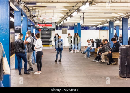 Bronx, Stati Uniti d'America - 28 Ottobre 2017: stazione della metropolitana piattaforma in transito sotterraneo in NYC Bronx Fordham Road altezze con segno, molte persone sedute Foto Stock