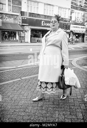 Bianco & Nero fotografia di una donna shopping a Tooting High Street a Londra, Inghilterra. Regno Unito, Credito: Londra Snapper Foto Stock
