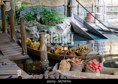 Due Imbarcazioni da fiume con cesti di frutta e verdura in acqua ormeggiata presso il molo. Vecchio dock in legno e palificazioni. Due barche vuote in background. Pic Foto Stock