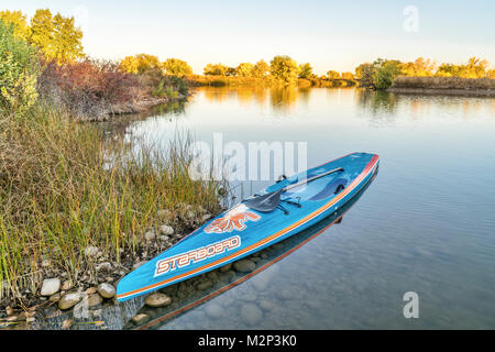 FORT Collins, CO, Stati Uniti d'America - 7 ottobre 2016: tutte le star racing stand up paddleboard da dritta in carbonio spazzolato layout con Werner racchetta su una riva di un Foto Stock