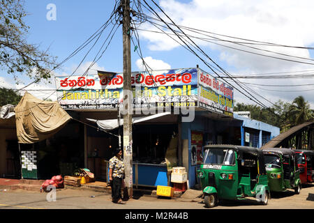 Colombo Road Pilimathalawa distretto di Kandy Sri Lanka Tuk Tuks parcheggiata fuori stallo di pesce Foto Stock