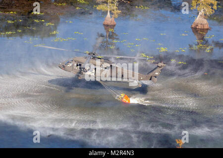 CADDO PARROCCHIA : un esercito della Louisiana National Guard UH-60 Black Hawk raccoglie acqua in un 500 gallone helibucket nel lago Caddo fuori Shreveport, La., nella parrocchia di Caddo, Sett. 6, 2011. La LANG i piloti hanno lavorato in un modello di pista per eseguire il dump di acqua sui punti caldi in prossimità della Highway 1 e 528 utilizzando helibuckets - benne di grandi dimensioni che trasportano l'acqua sospesa mediante cavo-per assistere il Ministero dell' agricoltura e delle foreste con la soppressione degli incendi. (U.S. Esercito Foto di Sgt. Rebecca Malone/Louisiana National Guard Public Affairs Office/RILASCIATO) Louisiana Army Guard UH-60 raccoglie acqua dal Nat Foto Stock