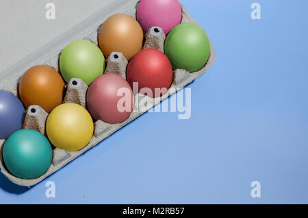 Closeup shot colorata con contenitore di cartone con le uova di gallina, dieci uova dipinte in colori diversi. Concetto di pasqua Foto Stock