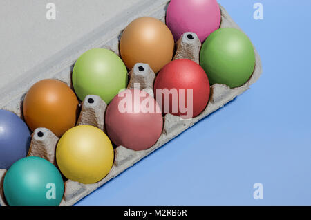 Closeup shot colorata con contenitore di cartone con le uova di gallina, dieci uova dipinte in colori diversi. Concetto di pasqua Foto Stock