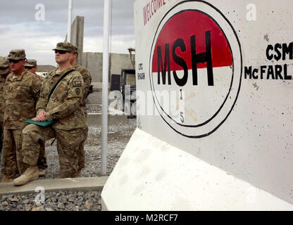 Silhuetted dalle unità crest dipinta su una barriera di sicurezza, Staff Sgt. Brian Beem, un amputato e della cavalleria Scout con il 5° Stormo, 1° reggimento di cavalleria, guarda come Col. Todd R. Legno, comandante della 1° Stryker Brigade Combat Team, XXV divisione di fanteria parla del vero significato di Beem le re-l'arruolamento. Beem ha perso la sua gamba durante una distribuzione in Iraq in 2006. Nonostante la perdita della sua gamba Beem continua a servire con i suoi compagni soldati di cavalleria. (U.S. Foto dell'esercito da: Sgt. Thomas Duval 1/25 SBCT affare pubblico) 111109-A-ESSERE343-008 da 1 Stryker Brigade Combat Team lupi artico Foto Stock