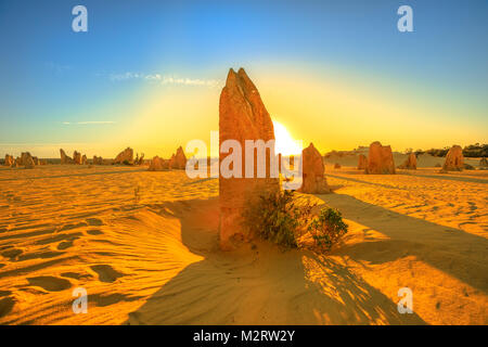 Giant la formazione di calcare illuminata dal tramonto rosso luce. Deserto Pinnacles nel Nambung National Park, Australia occidentale.Durante il tardo pomeriggio e suns Foto Stock
