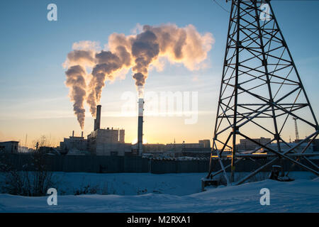 Un impianto per garantire il riscaldamento per il popolo di Yakutsk in Siberia rilascia fumo nell'aria come tramonto. Yakutsk è la seconda più fredda in grandi città Foto Stock