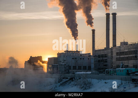 Un impianto per garantire il riscaldamento per il popolo di Yakutsk in Siberia rilascia fumo nell'aria come tramonto. Yakutsk è la seconda più fredda in grandi città Foto Stock