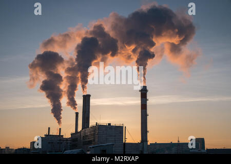 Un impianto per garantire il riscaldamento per il popolo di Yakutsk in Siberia rilascia fumo nell'aria come tramonto. Yakutsk è la seconda più fredda in grandi città Foto Stock