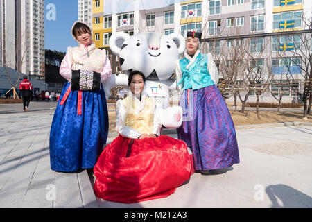 Gangneung, Corea del Sud. Il giorno 08 Febbraio, 2018. Corea del Sud le donne in abito tradizionale in piedi accanto a la mascotte Soohorang (C) nel villaggio olimpico in Gangneung, Corea del Sud, 08 febbraio 2018. Il Pyeongchang 2018 Olimpiadi invernali si svolgerà tra il 09 e 25 febbraio. Credito: dpa picture alliance/Alamy Live News Foto Stock