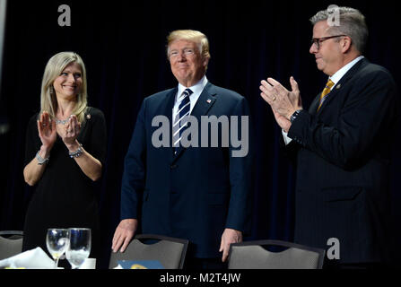 Il Presidente degli Stati Uniti, Trump, centro accetta applausi dal rappresentante statunitense Randy Hultgren (repubblicano di Illinois), destra, e sua moglie, Christy, sinistra, come egli arriva per la National Prayer Breakfast, 8 febbraio 2018, a Washington, DC. Migliaia di persone da tutto il mondo frequentano l annuale incontro ecumenico e ogni presidente dal Presidente Dwight Eisenhower ha affrontato l'evento. Credito: Mike Theiler / Pool via CNP /MediaPunch Foto Stock