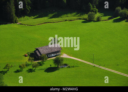 Haus in der Natur mit gruenen gras und wald Foto Stock