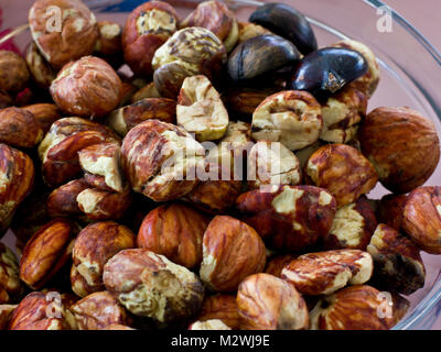 Grande sbucciate le castagne fresche nella ciotola di vetro Foto Stock